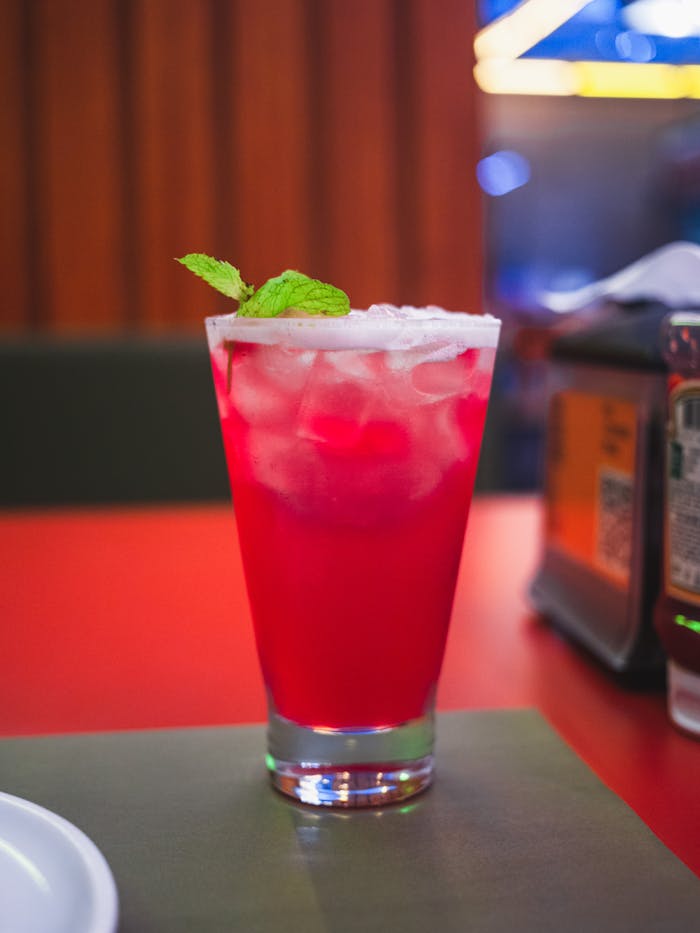 Chilled red drink with ice and mint, offering a refreshing taste.