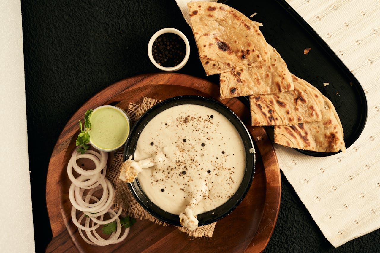 Top view of a traditional Indian meal featuring curry and flatbread, elegantly presented.