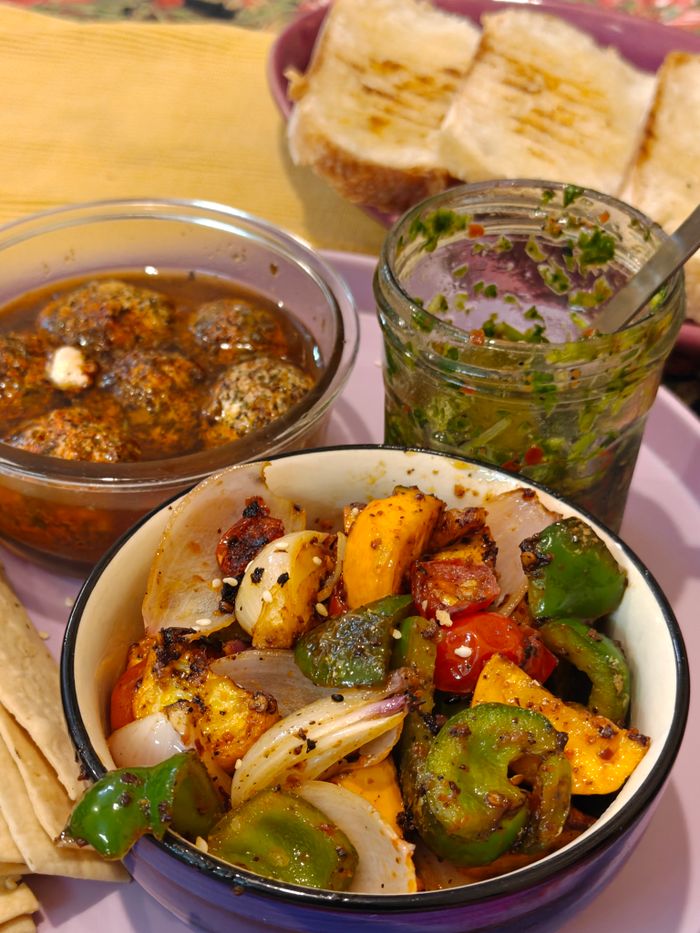 Delicious Indian vegetarian meal featuring grilled veggies, dips, and fresh bread.